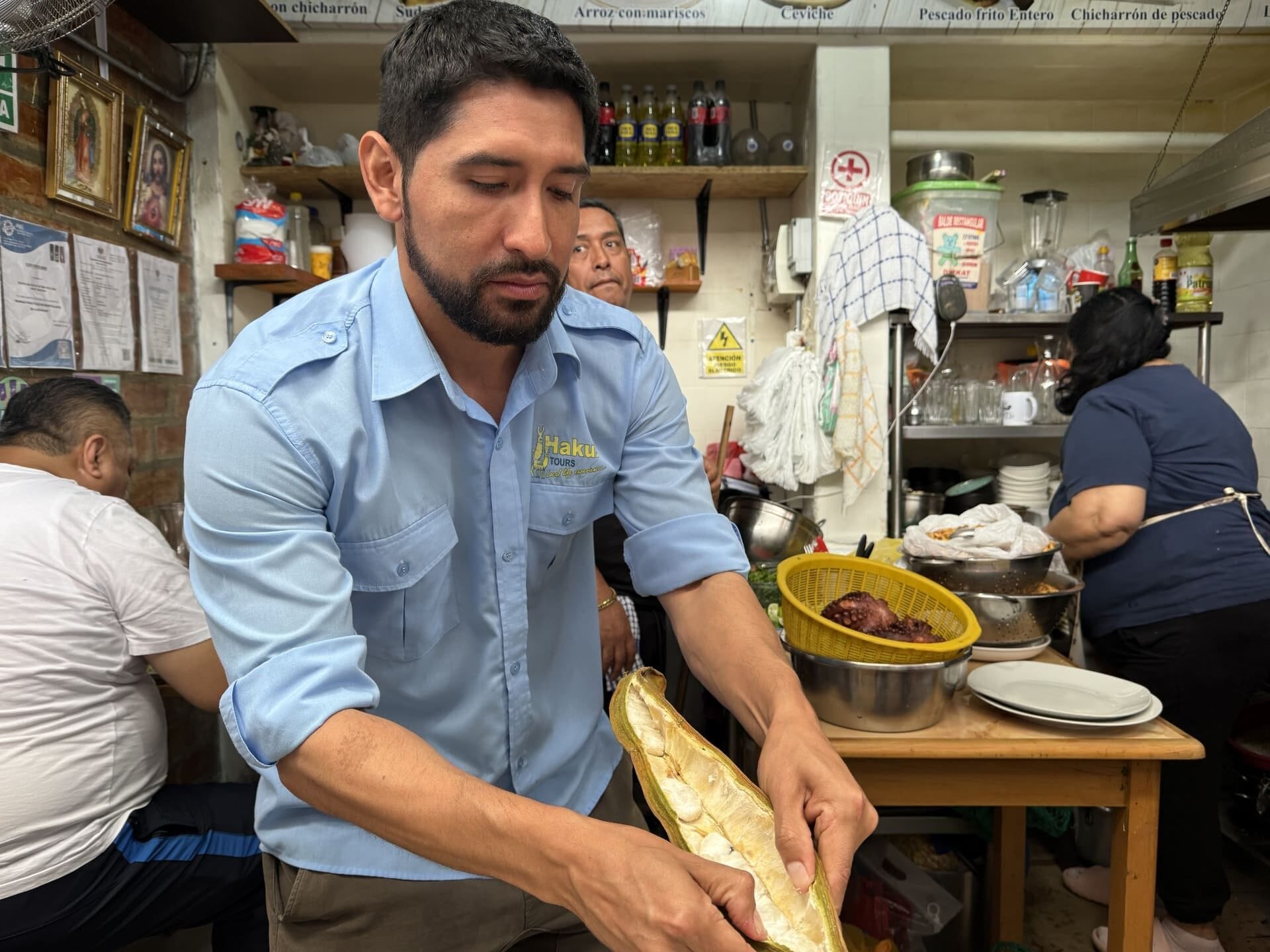 Guide Cesar Contreras opens a pacay pod to reveal its sweet fruit