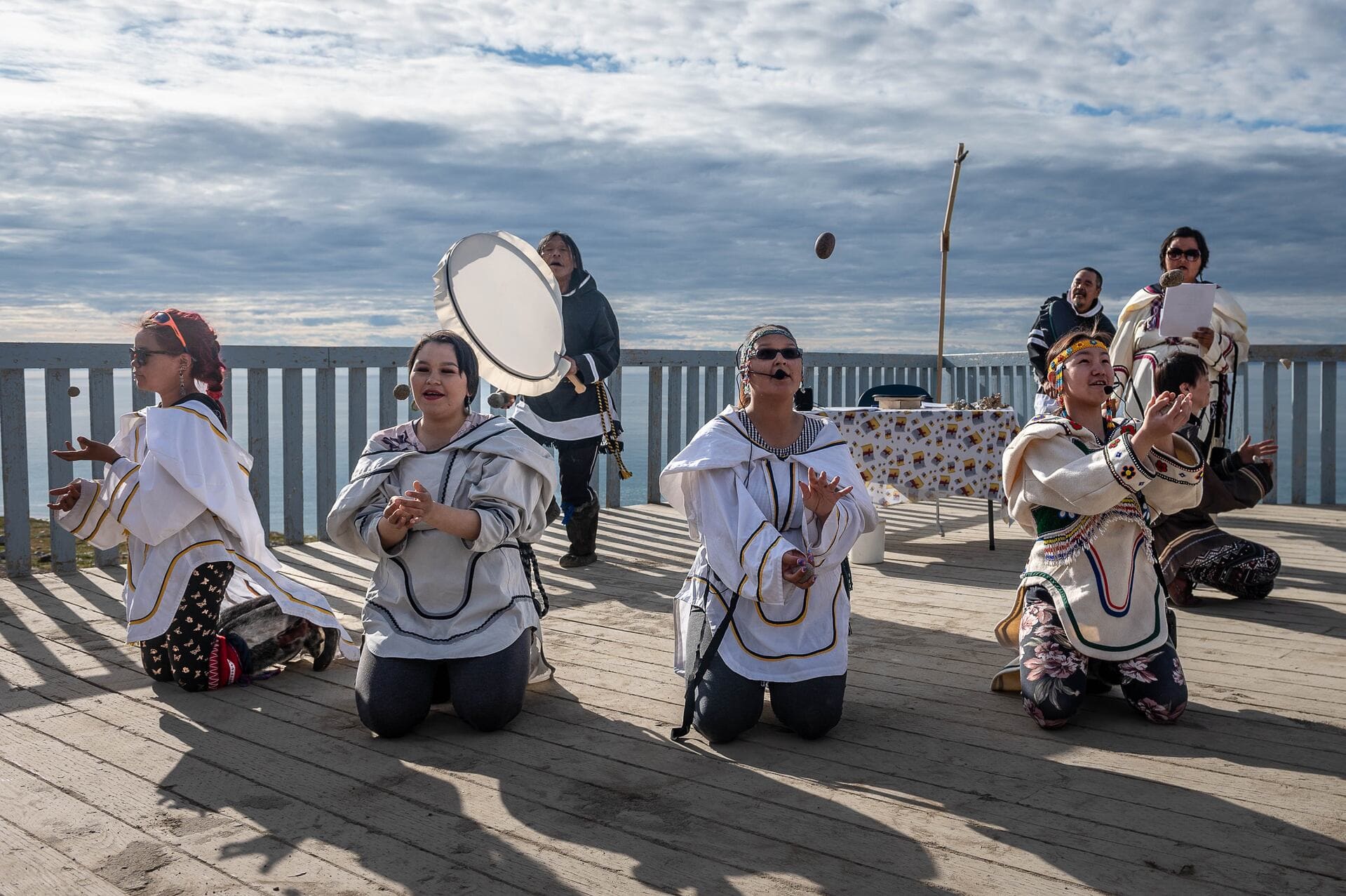 Indigenous cultural performance, traditional attire, drumming, coastal ceremony, cultural celebration