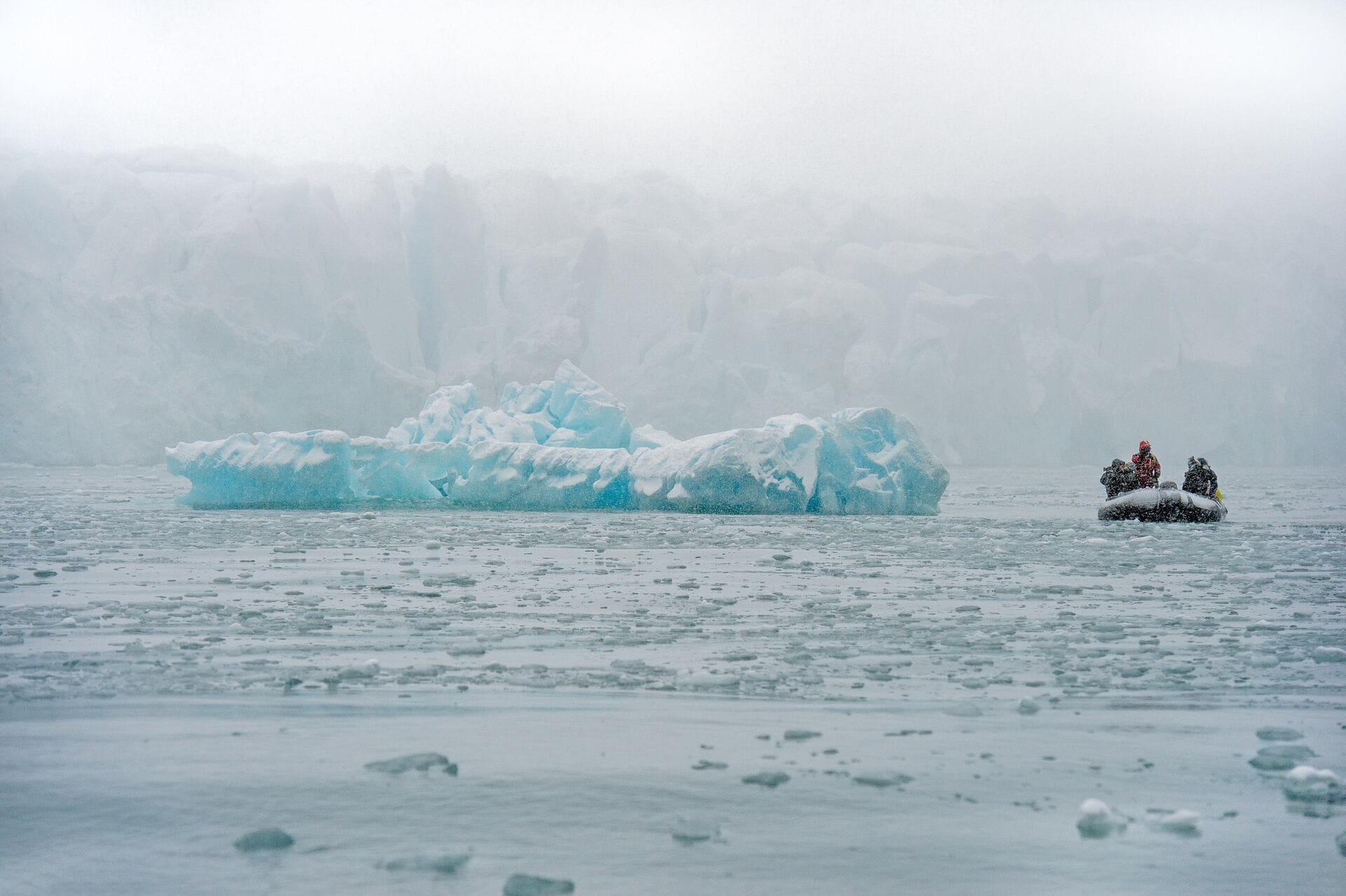 Arctic expedition, zodiac boat, iceberg, glacier, ice floes, snowfall, winter landscape