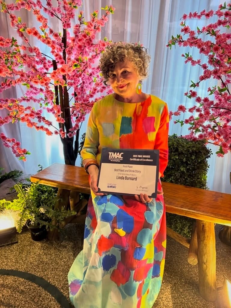 Linda Barnard – “Certificate of Excellence” from the 2025 TMAC Awards for “Best Food and Drink Story” Linda Barnard in a colorful dress holding a TMAC award certificate for