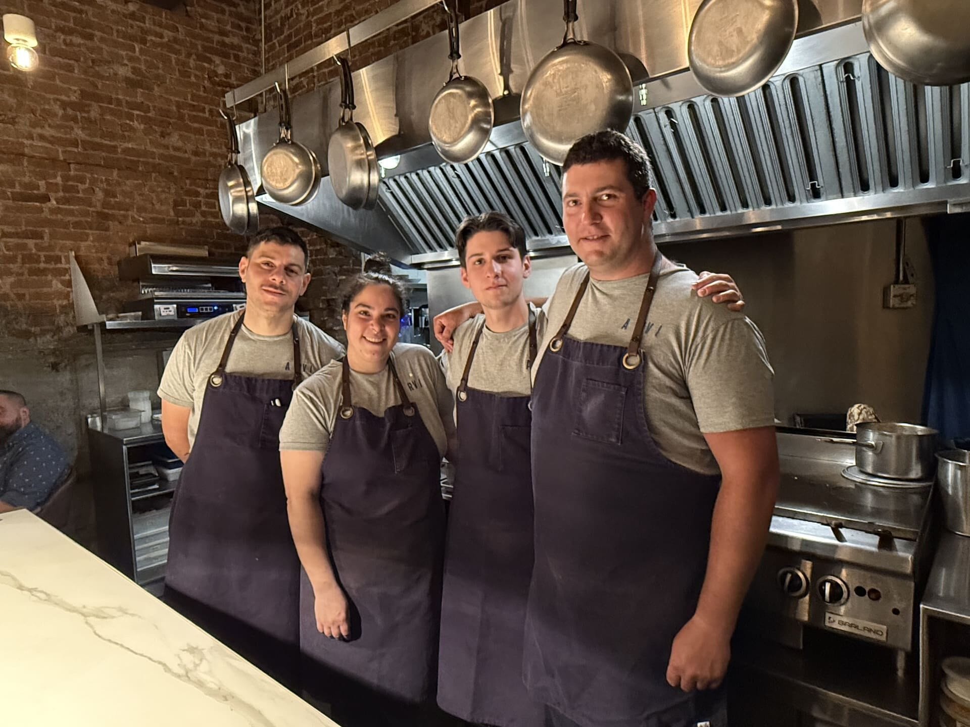 Chefs at Michelin-star ARVI in Limoilou make and serve dishes from an open kitchen.