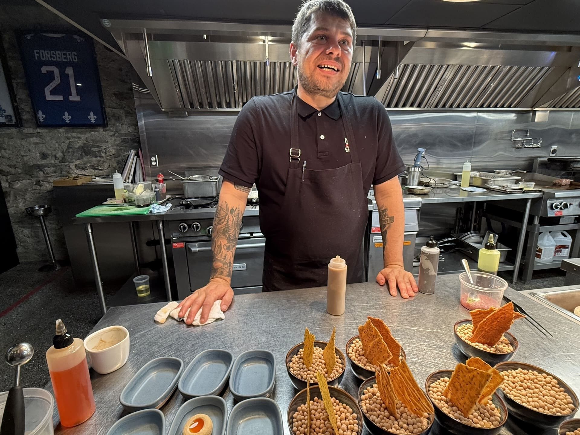 Chef Stéphan Modet preps starters in the open kitchen at Le Clan, which uses local foragers, farmers, and purveyors. It has its first Michelin star.