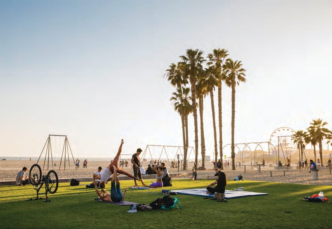 people enjoying the sunset while exercising on the grassy area near Muscle Beach in Santa Monica, California