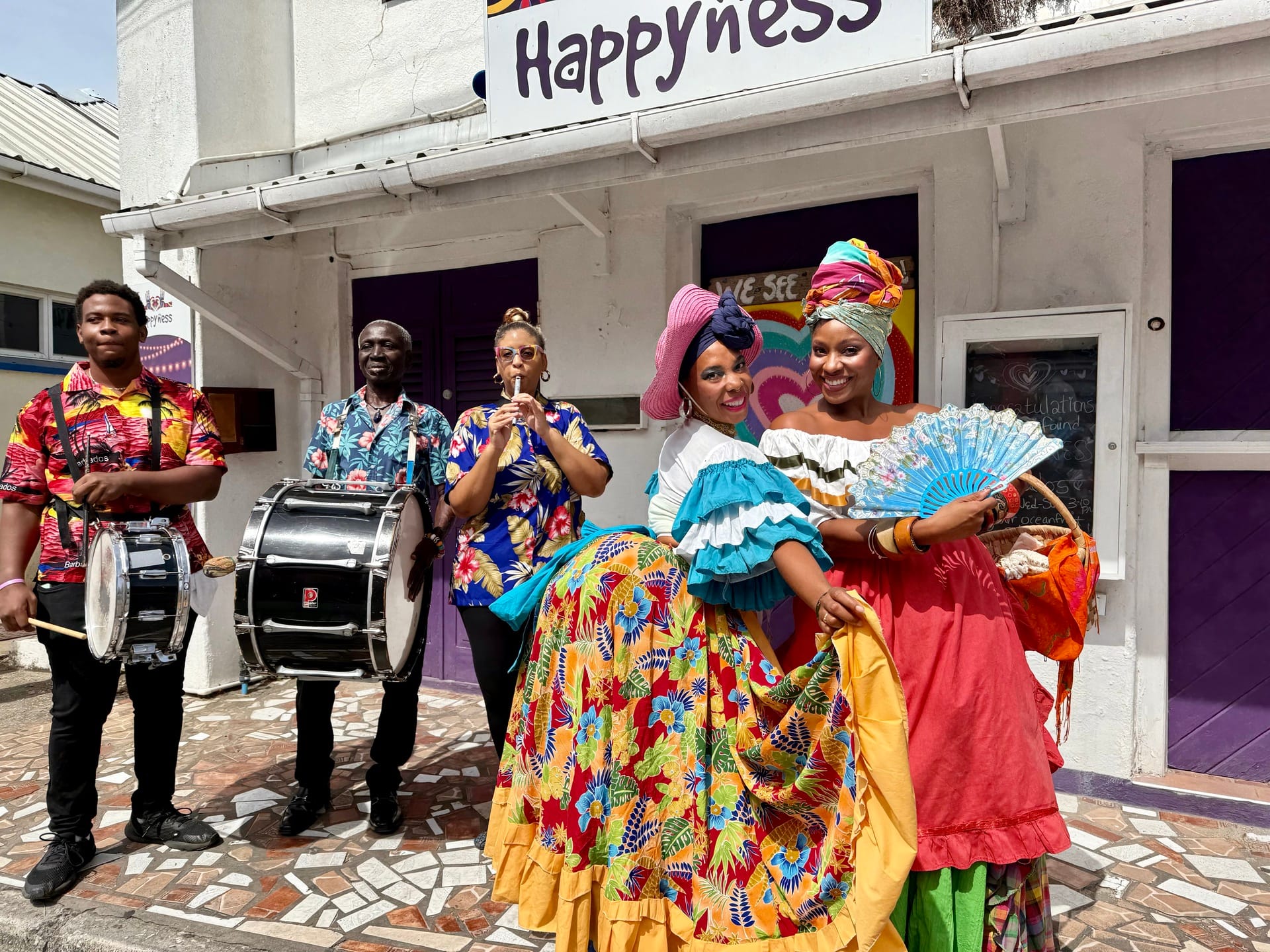 A group of colourfully dressed characters accompanied by a tuk band perform in Speightstown, Barbados